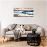 Neutral-toned living room with a light gray sofa, a white and brown dog sitting on it, a textured gray throw, a round black wicker coffee table, and a framed ocean wave painting above.