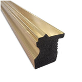 Close-up of a gold-colored metal frame molding with a grooved decorative profile and black textured backing, shown at an angle on a white background.