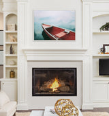 Living room with white built-in shelves, modern fireplace with burning logs, and wall art of a red boat floating on calm blue water.