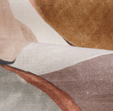 Close-up of the Figura Pillow Cover in Mehndi featuring soft fabric with abstract shapes in muted orange, rusty red, and beige tones on textured cloth.