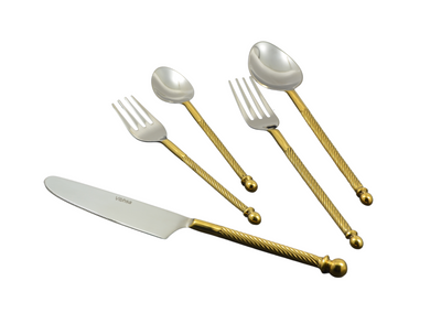 Golden stainless steel flatware set of 20 pieces with swirled handles laid out on table