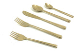 Set of five gold flatware pieces including two forks, a knife, and two spoons with textured handles arranged on a white surface.