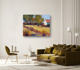 Impressionist-style autumn landscape painting with golden fields, trees with autumn foliage, and a small white house with a red roof hanging on a beige wall in a modern living room.