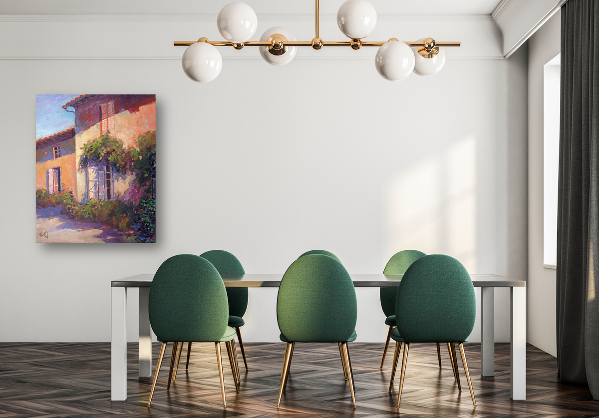 Dining room with a modern rectangular table, six green upholstered chairs with gold legs, a brass chandelier with six white globe lights, and an impressionistic painting on a white wall.