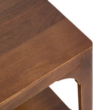 Close-up of a brown wooden rectangle coffee table corner showing smooth rounded edges and curved leg with an open lower shelf underneath.