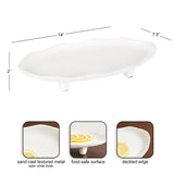 White oval decorative tray with a deckled edge, raised on three short legs, made from sand-cast textured metal with a satin finish and food-safe surface.