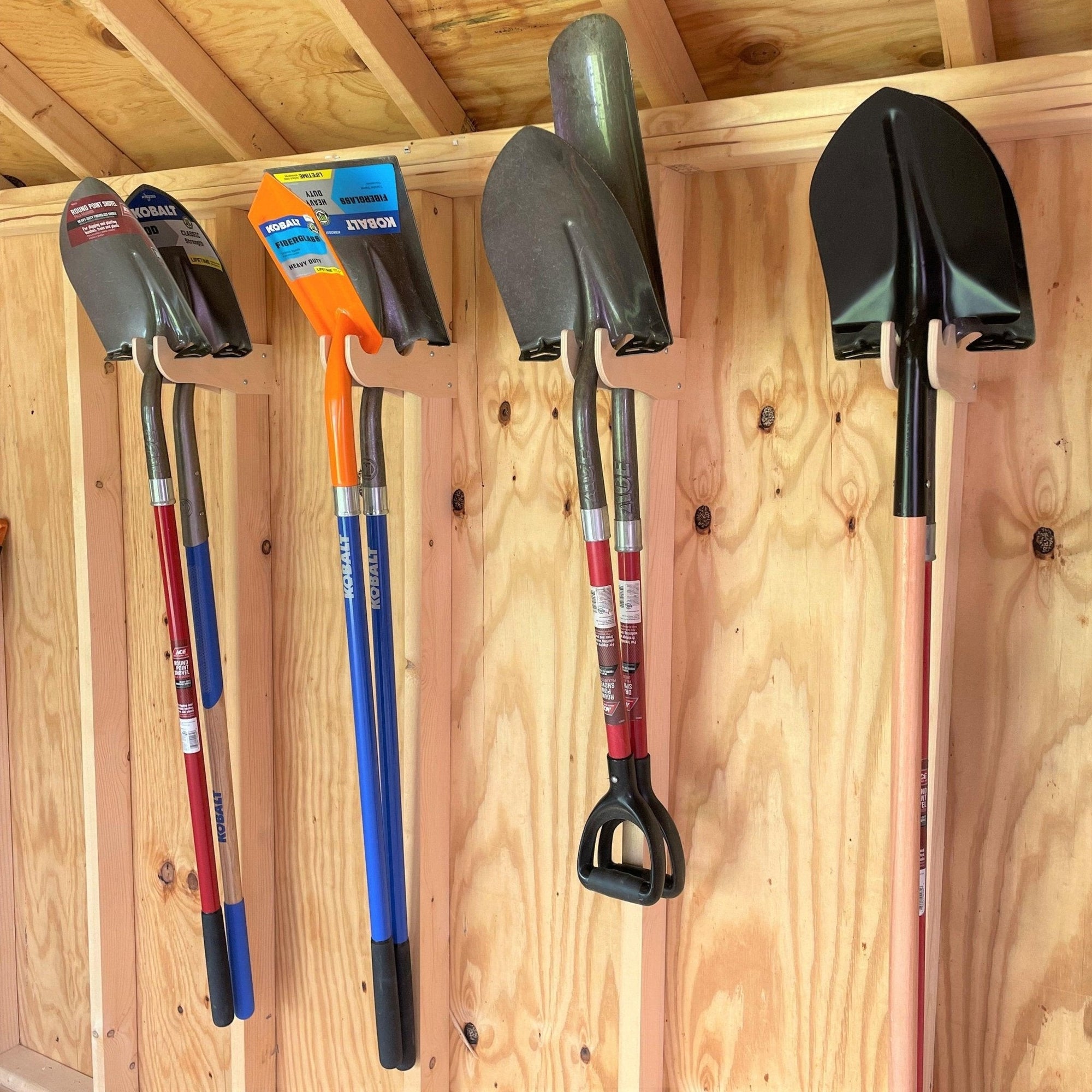 Garden Tool Organizer Hooks mounted on a wall holding garden tools