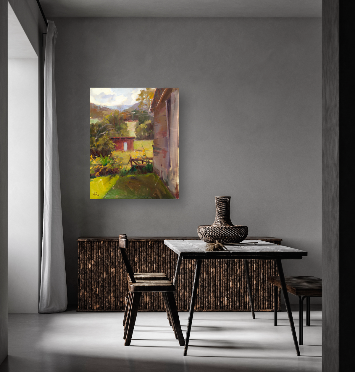 Square canvas print of a garden shed scene with warm sunlight, green plants, and a rustic wooden structure, hung on a gray wall above a minimalist table and chairs.