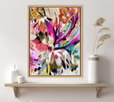 Abstract floral painting with vivid pinks, purples, and blues accented by black and yellow brushstrokes in a light wooden frame above a wooden shelf with minimalist vases and dried grasses.