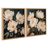 Two framed canvas paintings featuring large, soft white and blush floral bouquets with dark green leaves on a deep navy background, in light wooden frames.
