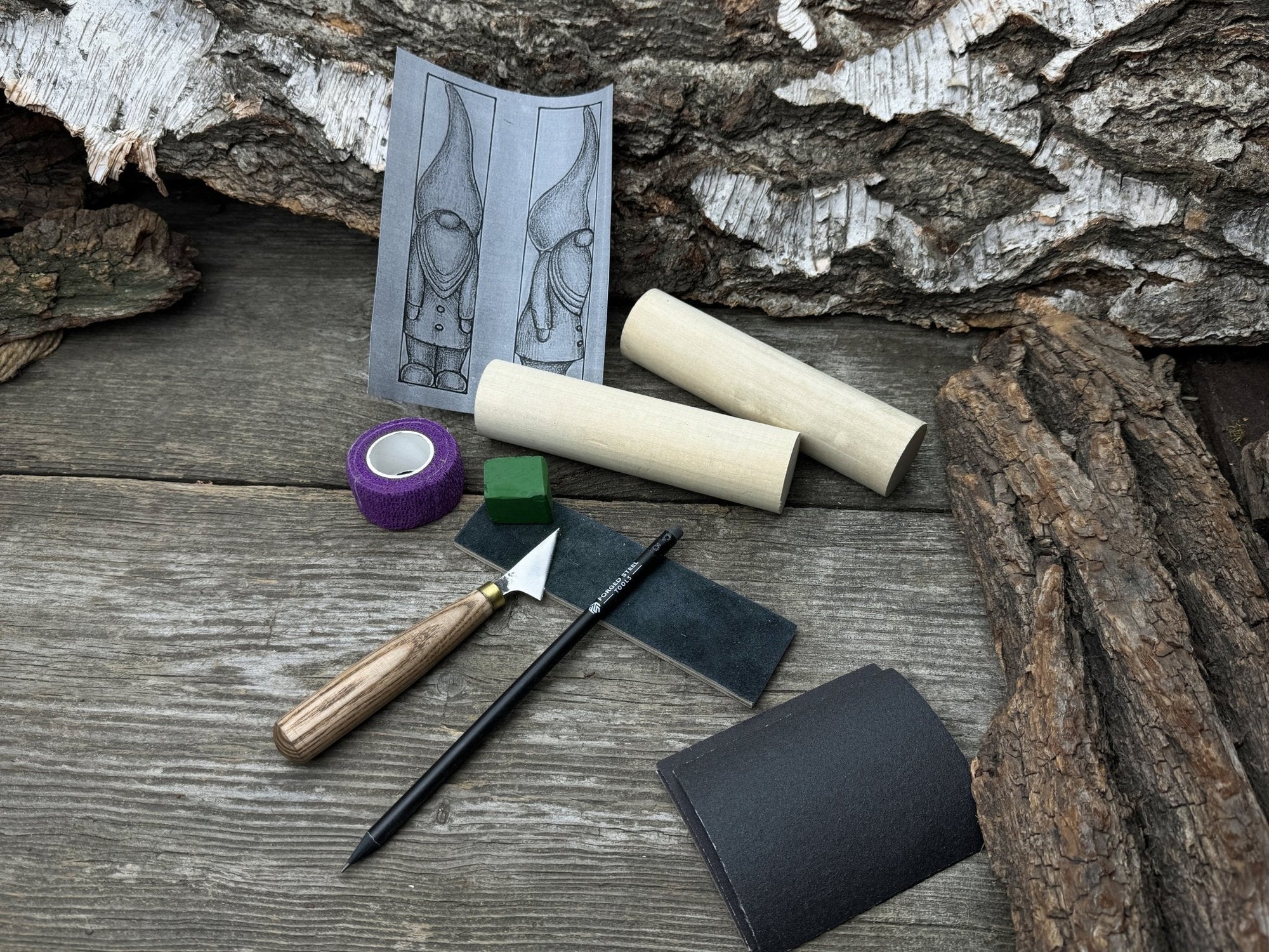 Gnome Carving Kit with carving knife, wooden blocks, sandpaper, sharpening board, pencil, and gnome drawing template