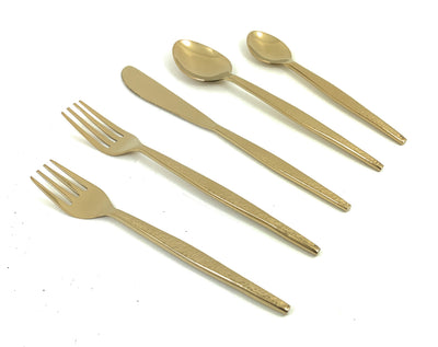 Vibhsa 20 Piece Gold Flatware Set with hammered texture laid out on table