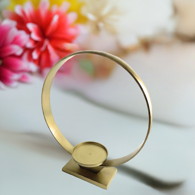 Vibhsa Golden Ring Candle Holder showing large golden circular ring with pillar candle on rectangular base