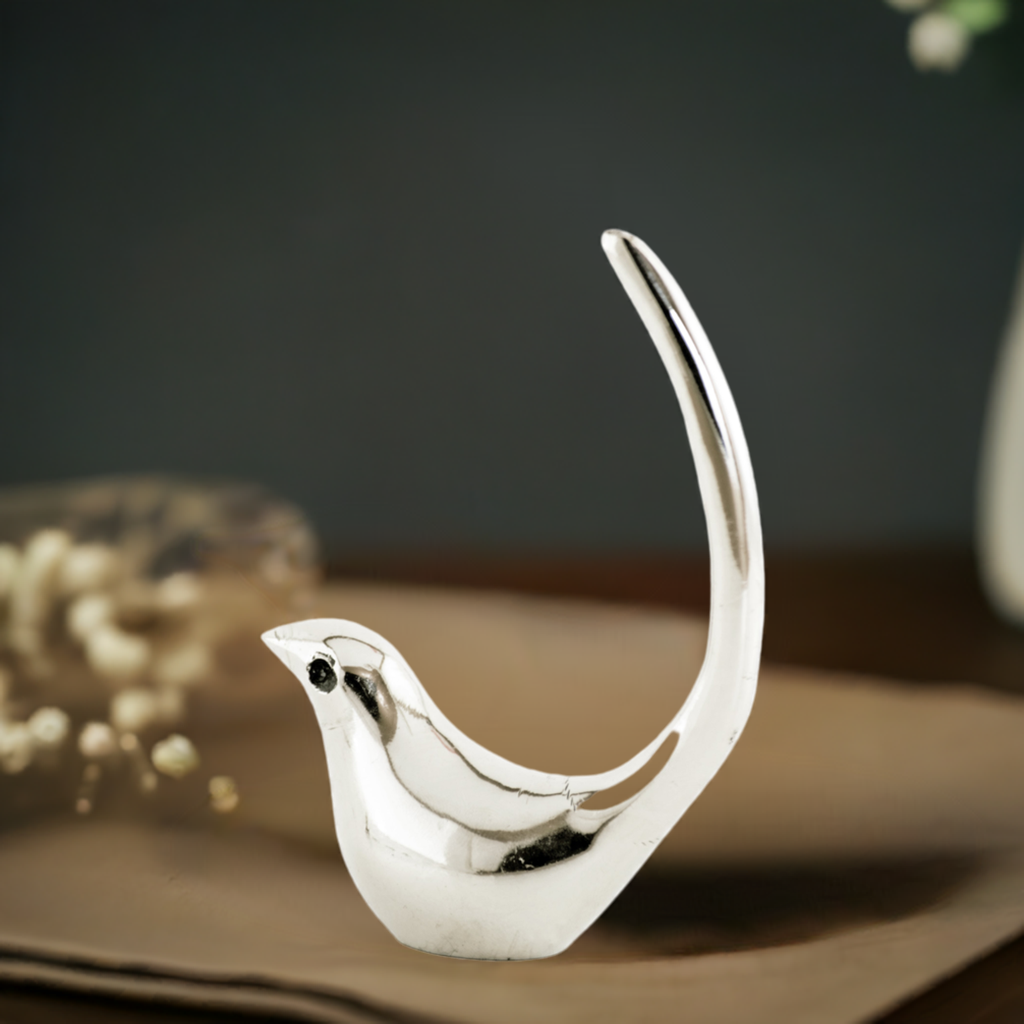 Silver bird ring holder jewelry organizer on white surface