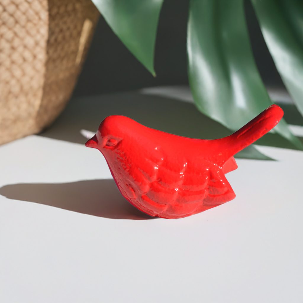 Red handcrafted aluminum bird figurine by Vibhsa displayed on a white surface