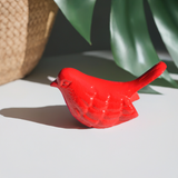 Red handcrafted aluminum bird figurine by Vibhsa displayed on a white surface