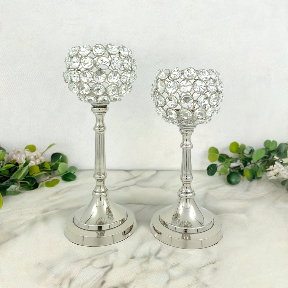 Vibhsa Hurricane set of two crystal candle holders placed with tea light candles, showing silver nickel aluminum bases and crystal accents.