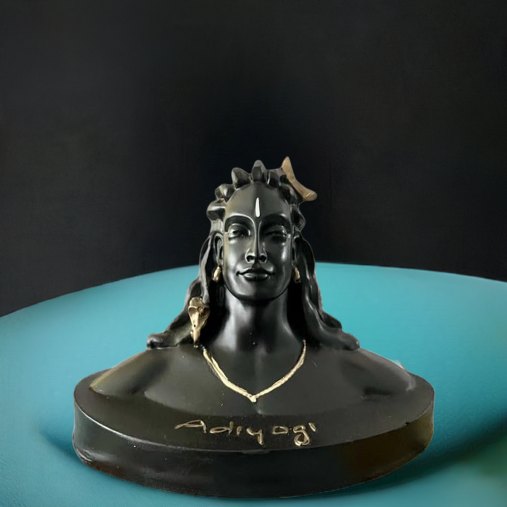Black resin bust of Adiyogi with detailed facial features and hair, adorned with a gold necklace and a gold element in the hair, set on a turquoise surface.