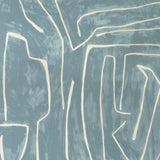 Close-up of a pillow cover with a hand-painted abstract line pattern in cream on a muted blue-gray background, creating organic, branching shapes.