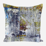Square pillow with abstract design featuring dominant shades of gray and white, accented by patches of green, blue, and muted brown in textured brushstroke patterns.