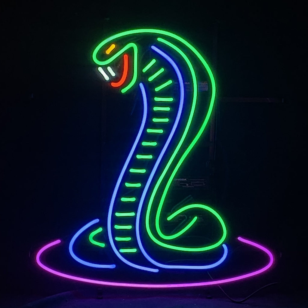 Green illuminated Shelby Cobra neon sign with metal grid backing