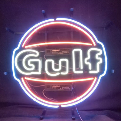 Gulf Gasoline Neon Sign glowing against dark indoor wall with metal grid backing
