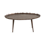 Oval wooden coffee table with scalloped edges and three tapered legs, finished in a warm medium brown tone against a white background.
