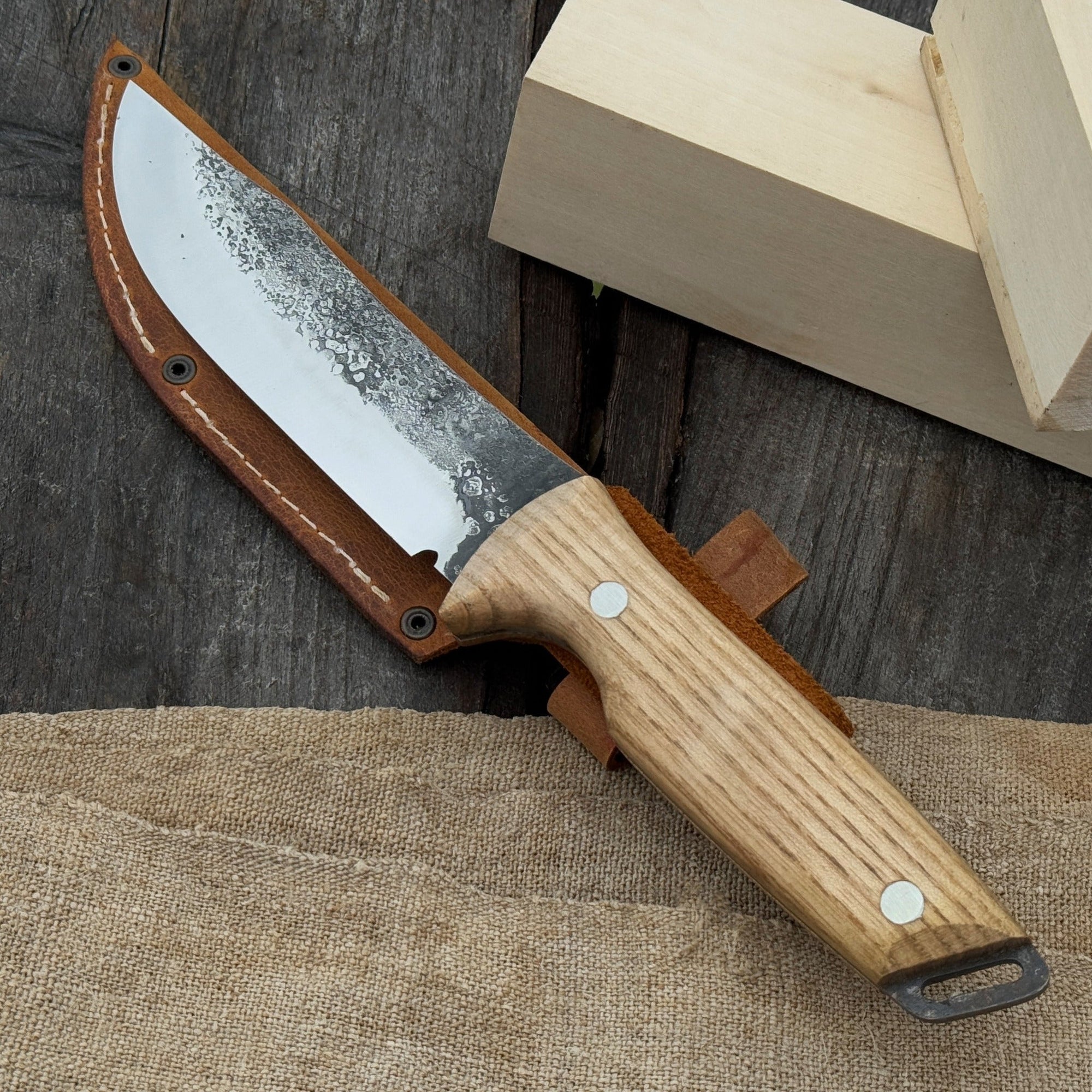 Hand-forged bushcraft knife with 12 cm carbon steel blade and ash wood handle by Sharky Forged Steel Tools