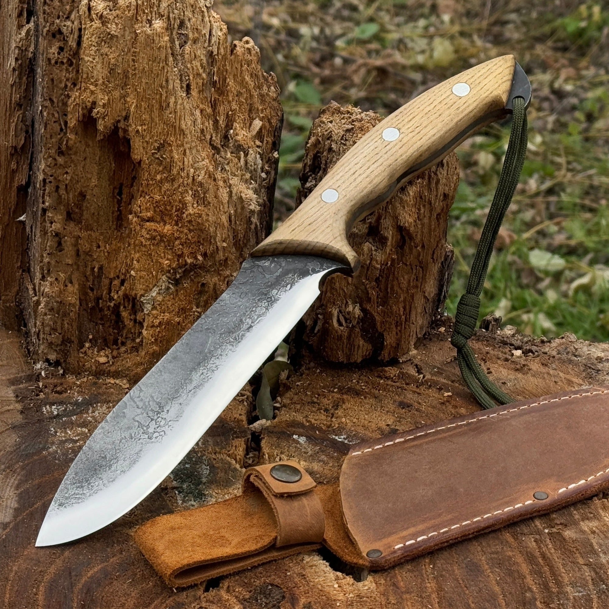 Hand-forged bushcraft knife with carbon steel blade and ash wood handle