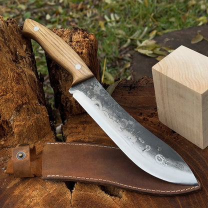 Hand-forged bushcraft knife with 17 cm carbon steel blade and ash wood handle, accompanied by leather sheath