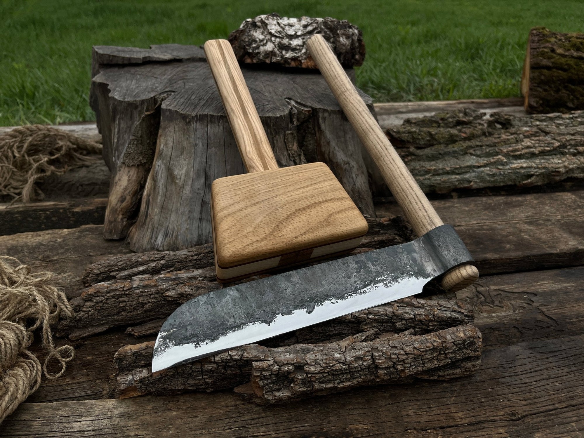 Hand-forged splitting froe with wooden mallet on wooden surface