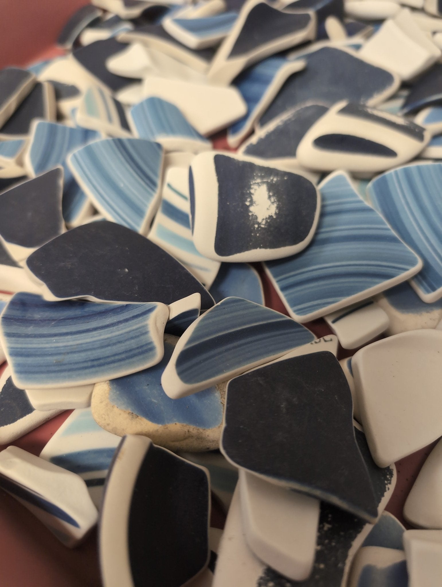 Assorted hand-tumbled pottery pieces in earthy colors for mosaic crafts