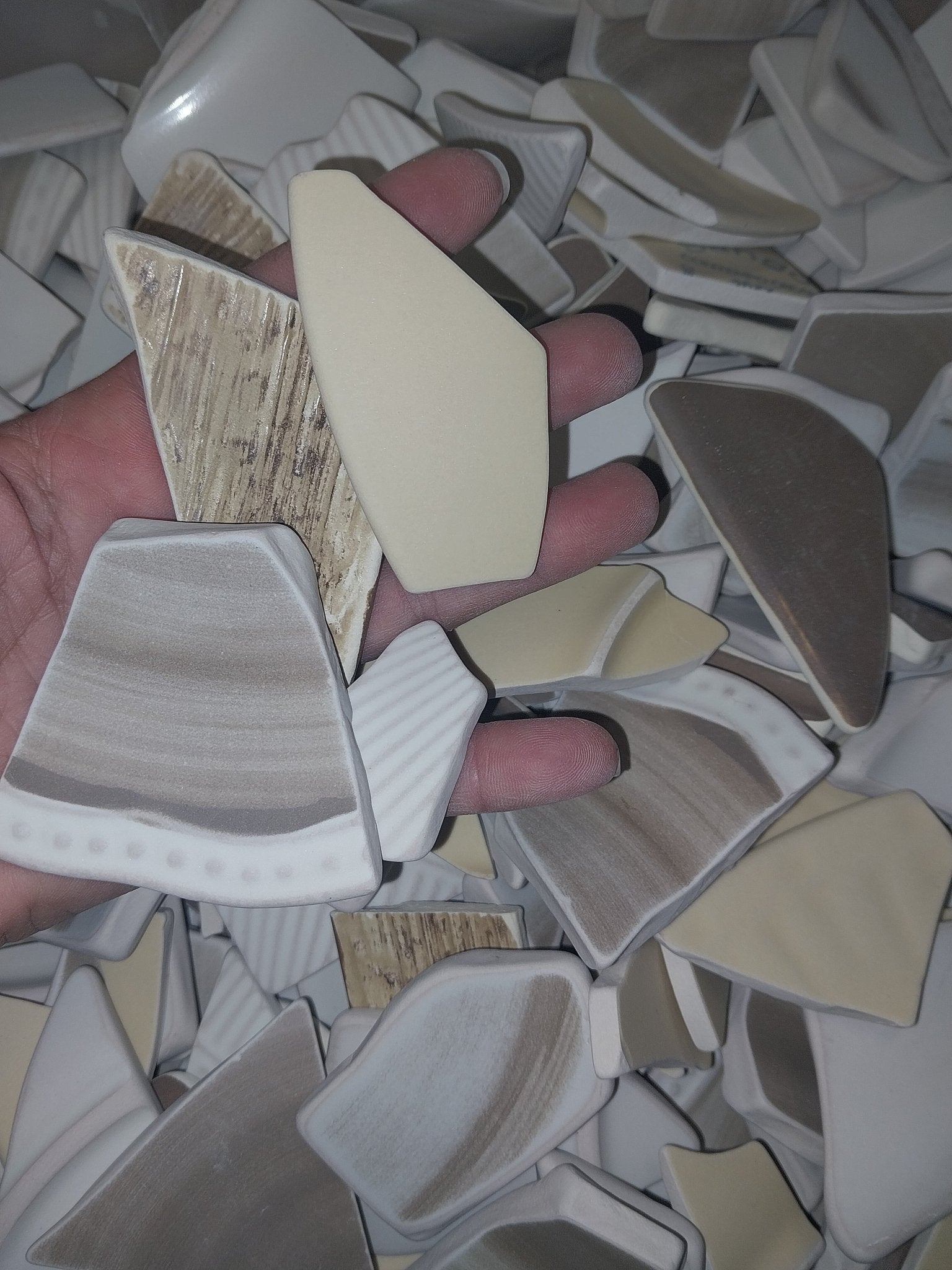 Assorted hand-tumbled pottery pieces in earthy colors for mosaic crafts