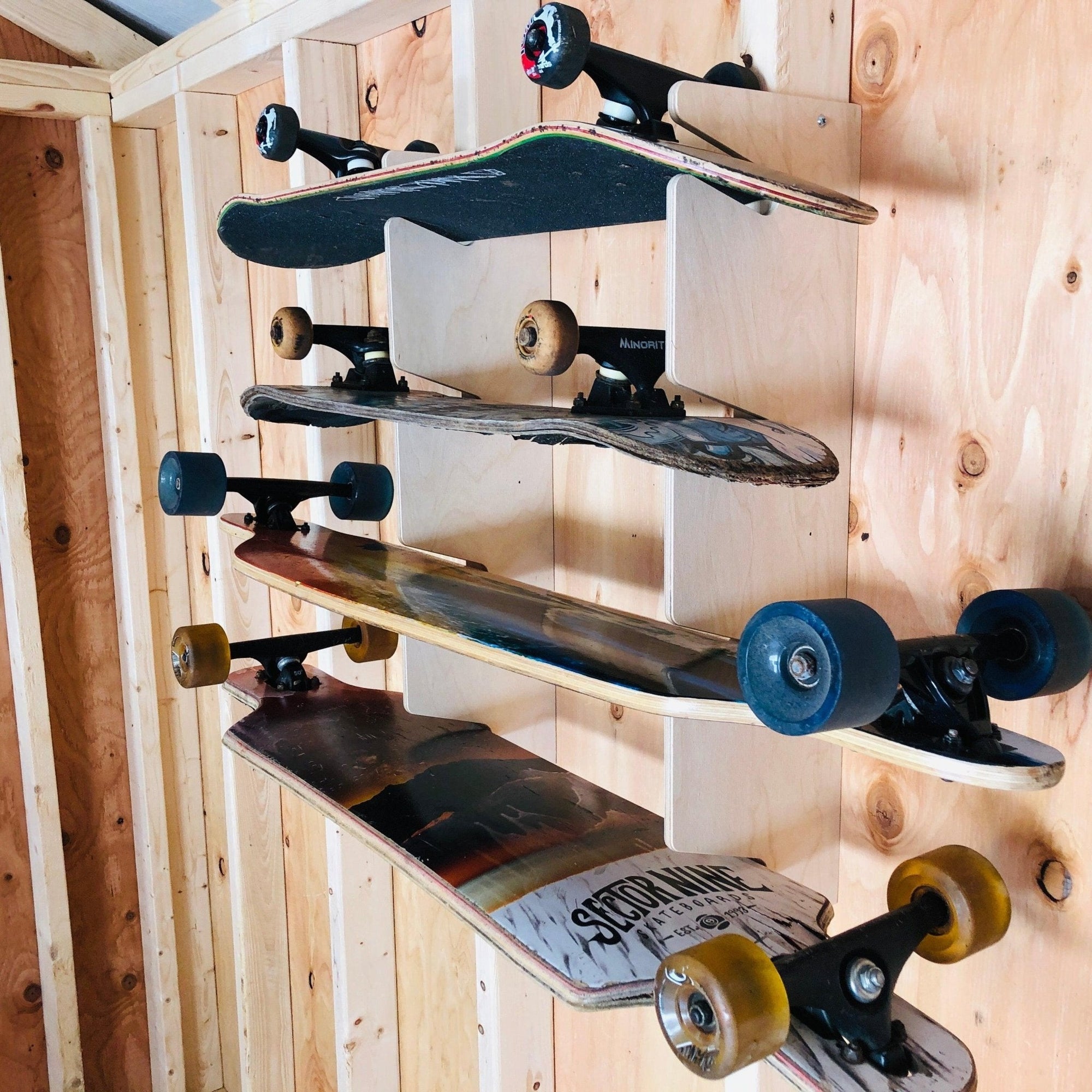 Wall-mounted Skateboard Organizer by HangThis Up holding four skateboards in a garage setting