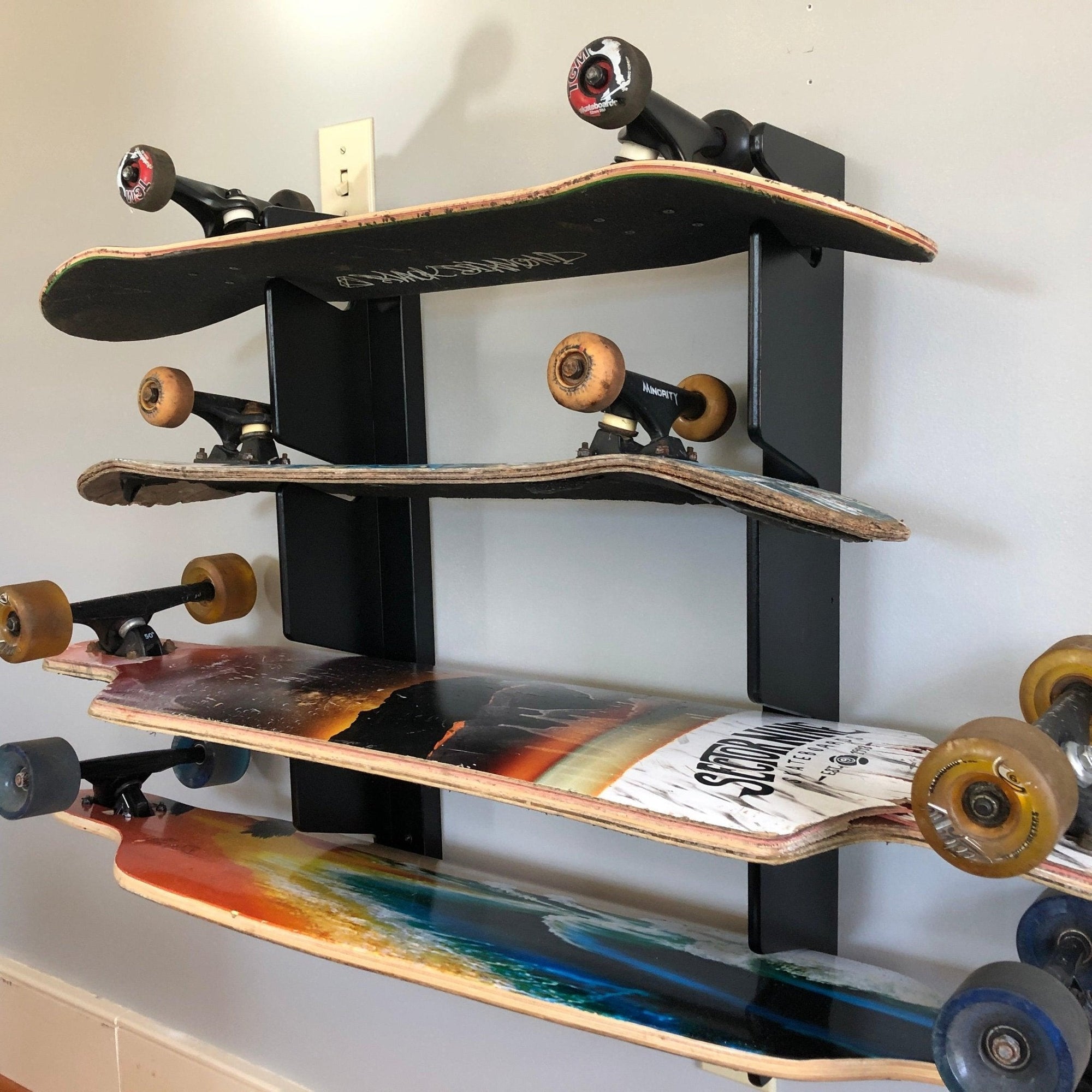 Wall-mounted Skateboard Wall Organizer by HangThis Up holding multiple skateboards