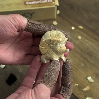 Complete Hedgehog Carving Kit with knife, wooden blocks, sandpaper, sharpening board, pencil, and hedgehog drawing