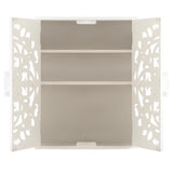 White wall cabinet with double doors featuring intricate symmetrical floral cutout patterns and two interior shelves against a plain background.