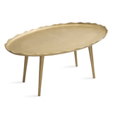 Oval table with a scalloped edge and smooth surface in a warm beige tone, supported by four slender, slightly tapered legs angled outward.
