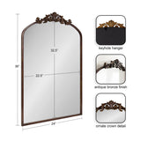 Arched mirror with an antique bronze-finished frame featuring an ornate crown detail at the top and a keyhole hanger on the reverse side for mounting.