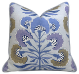 Square pillow with a pale background featuring a symmetrical floral pattern in blue, lavender, and muted olive green with white accents.