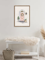 Framed canvas of a pink front door with a Christmas wreath, small potted tree, and package, hanging above a white bench with a fluffy throw and gray bag.