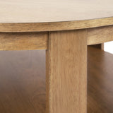 Close-up of a round wood coffee table leg and underside of the top showing light natural wood grain and smooth edges with a shelf beneath.