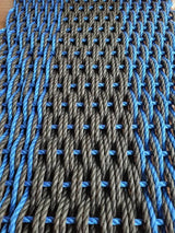 Large double weave lobster rope door mat in vibrant colors on porch