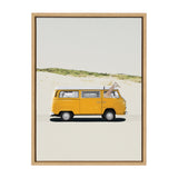 Yellow vintage van with a giraffe's head and neck extending out of the front passenger window against a sandy background with greenery line and plain sky