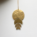 Just a Phase Ornament hanging, showing its thin brass phases with a hanging cord