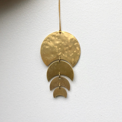 Just a Phase Ornament hanging, showing its thin brass phases with a hanging cord
