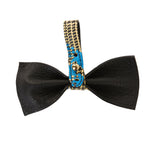 Black leather bowtie with a blue and beige plaid leather strap featuring a gold-tone button closure at the center, shown against a white background.