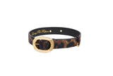 Black leather collar with abstract leopard print pattern and oval vintage gold buckle on a white background.