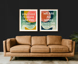 Two abstract modern art prints with warm tones and organic shapes hang above a mid-century modern tan leather sofa against a dark wall.