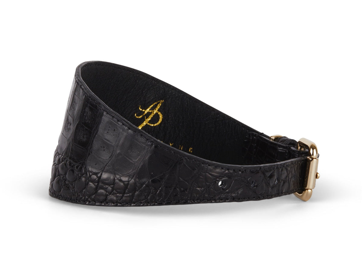 Black 3-inch wide collar with crocodile texture and gold-tone hardware, shown lying flat with a slight curve.